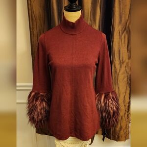 Burgundy sweater with furry sleeves.